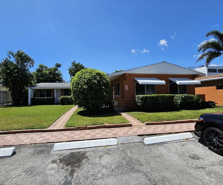 Single-story 4-plex with landscaped front lawns and palm trees on NE 46th Street, Fort Lauderdale