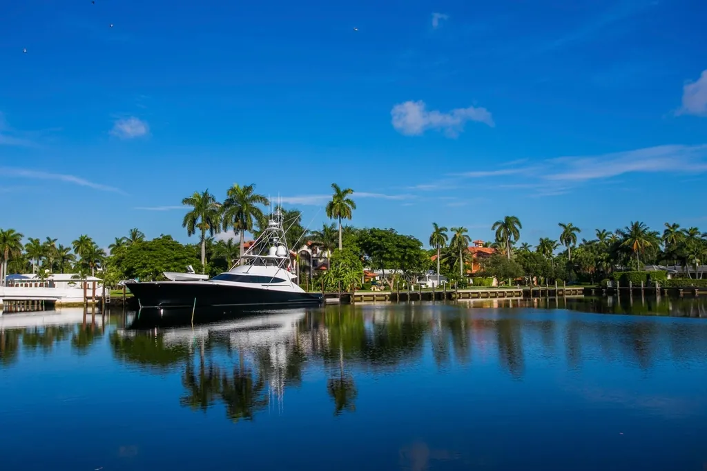 Yacht moored on a calm Fort Lauderdale canal lined with palms